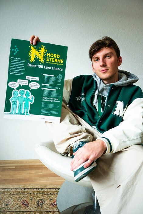 Dual student Miguel Fraczek shows a poster of the Nordsterne scholarship