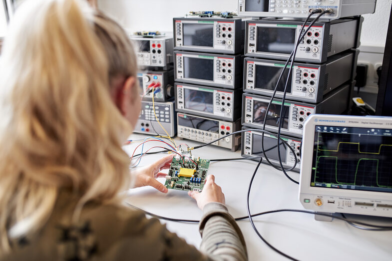 The picture shows a person holding a chip upright in their hands so that the photodiode reacts to the incidence of light and the resulting frequencies can be measured.